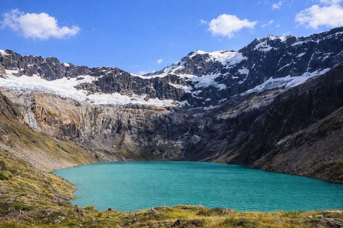 Laguna Amarilla turquoise crater lake beneath El Altar peaks during El Altar Ecuador Tours